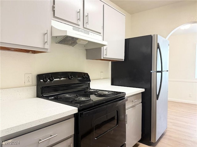 kitchen featuring white cabinets, light hardwood / wood-style floors, black electric range oven, and stainless steel refrigerator