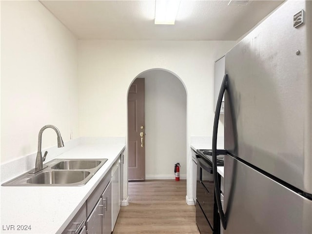 kitchen with sink, stainless steel appliances, and light hardwood / wood-style flooring