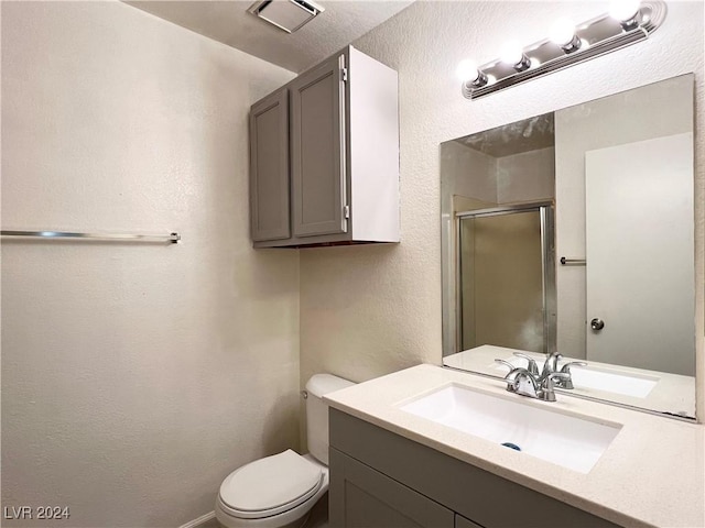 bathroom featuring vanity, toilet, and an enclosed shower