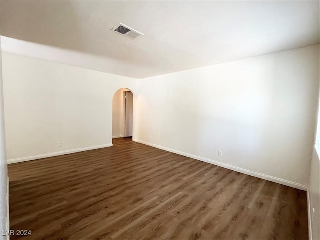 unfurnished room with dark wood-type flooring