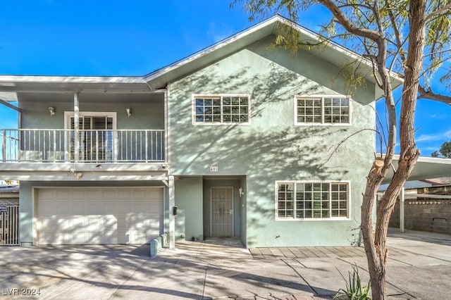 view of front of property featuring a balcony and a garage