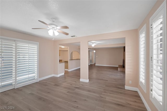 unfurnished living room with hardwood / wood-style flooring, plenty of natural light, and ceiling fan