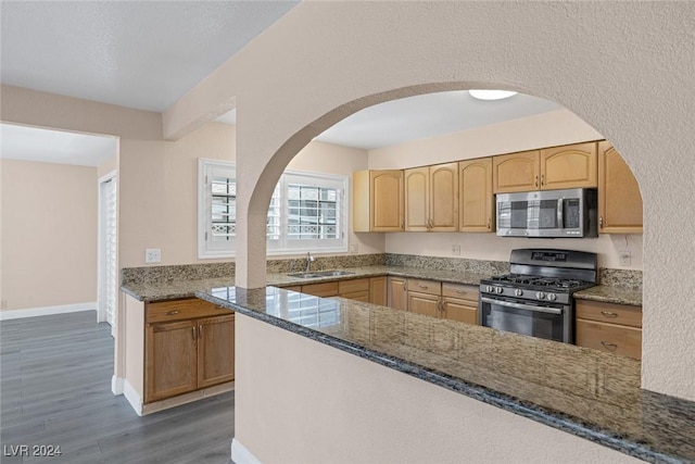 kitchen featuring light brown cabinets, dark stone counters, sink, dark hardwood / wood-style floors, and stainless steel appliances