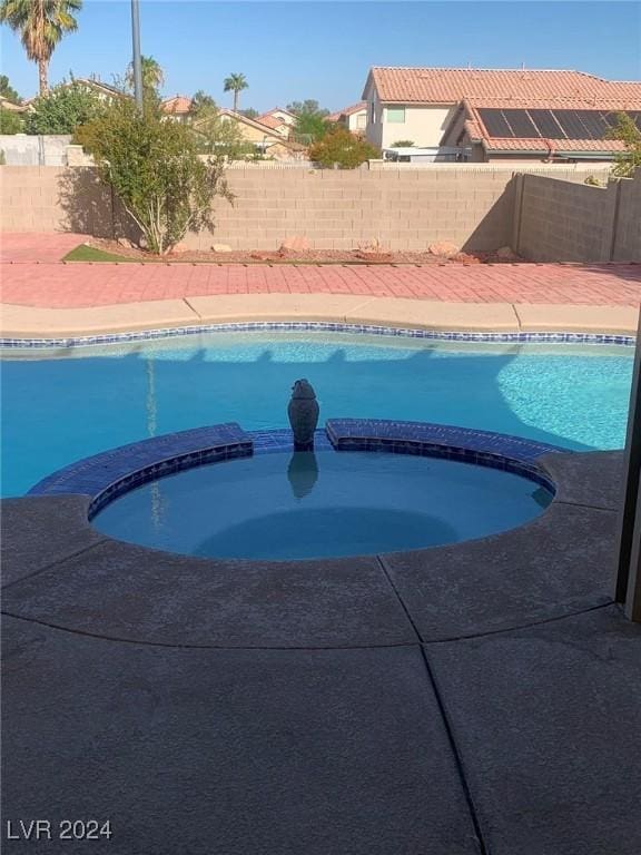 view of swimming pool with an in ground hot tub