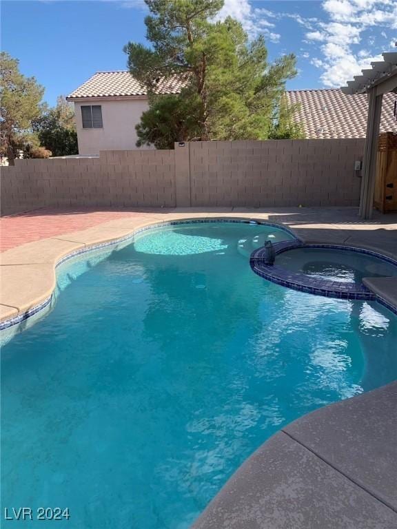 view of swimming pool featuring an in ground hot tub