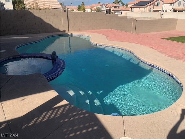 view of swimming pool featuring a patio area and an in ground hot tub