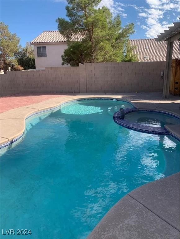 view of swimming pool featuring an in ground hot tub