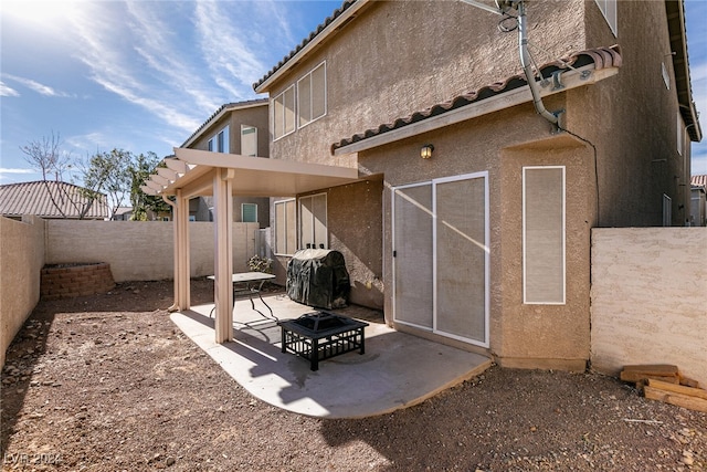 rear view of house with a patio and an outdoor fire pit