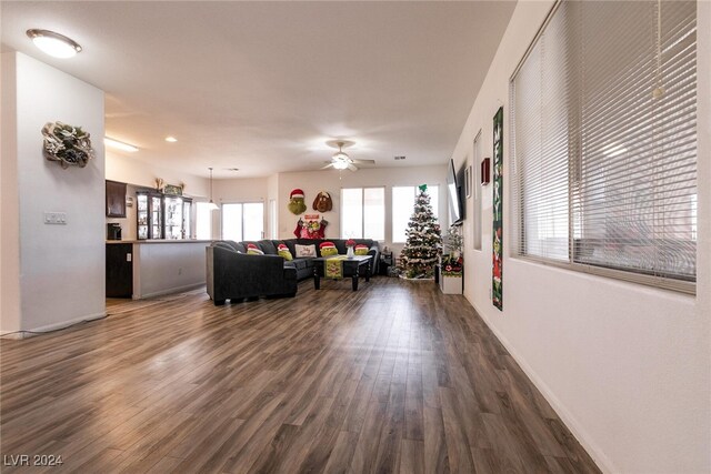 living room featuring ceiling fan and dark hardwood / wood-style flooring