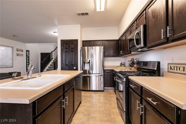 kitchen with dark brown cabinets, a center island, sink, and appliances with stainless steel finishes