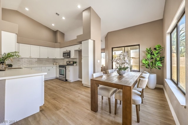 kitchen with sink, white cabinetry, light hardwood / wood-style floors, tasteful backsplash, and appliances with stainless steel finishes