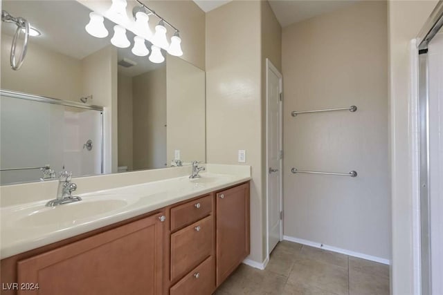 bathroom with tile patterned flooring, vanity, and a shower with door