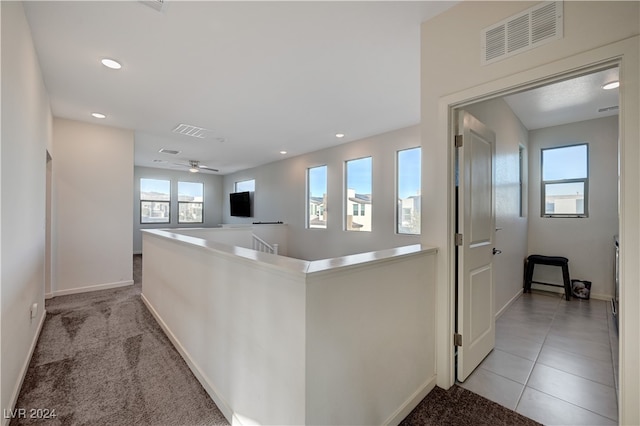 kitchen featuring kitchen peninsula, ceiling fan, and light colored carpet