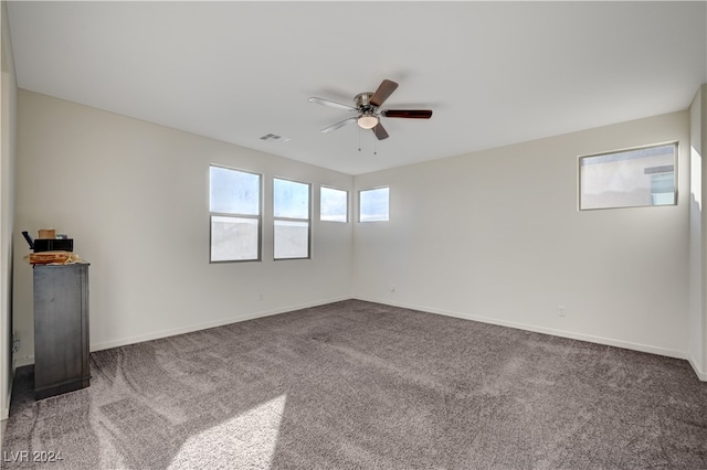 carpeted spare room featuring ceiling fan