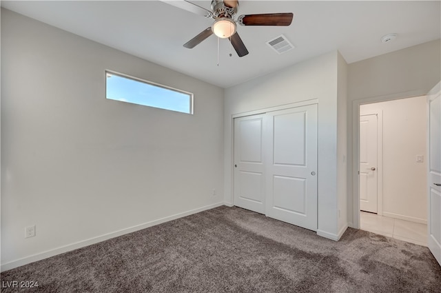 unfurnished bedroom featuring ceiling fan, light carpet, and a closet