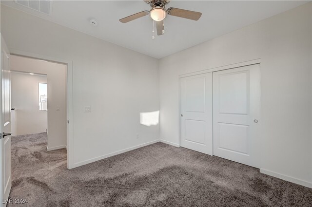 unfurnished bedroom featuring ceiling fan, light colored carpet, and a closet