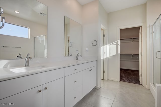 bathroom with tile patterned flooring, vanity, and walk in shower