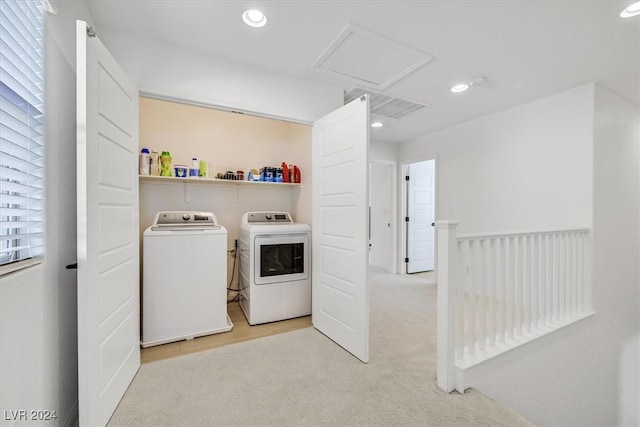 clothes washing area featuring washer and dryer, a healthy amount of sunlight, and light colored carpet