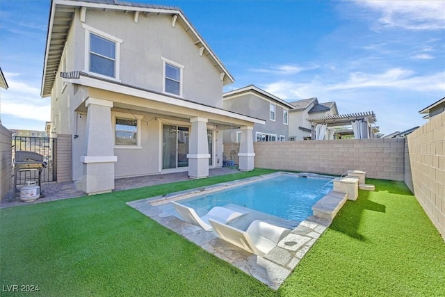 back of house with a yard, pool water feature, and a fenced in pool