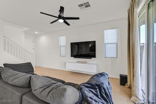 living room featuring ceiling fan and light hardwood / wood-style flooring