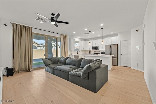 living room featuring ceiling fan and light wood-type flooring