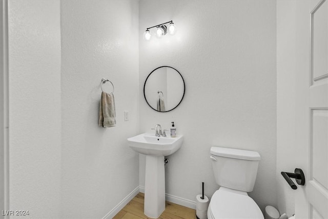 bathroom featuring hardwood / wood-style flooring, toilet, and sink