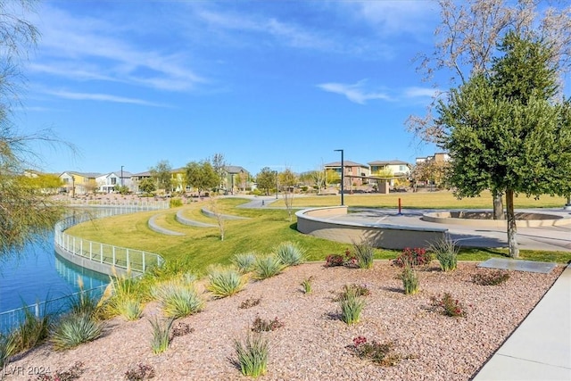 surrounding community with a lawn and a water view