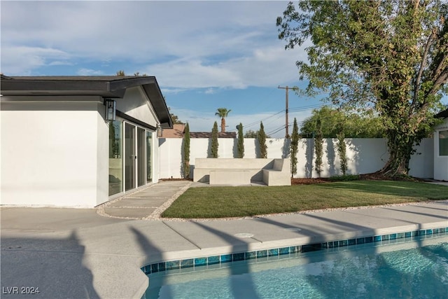 view of swimming pool with a lawn