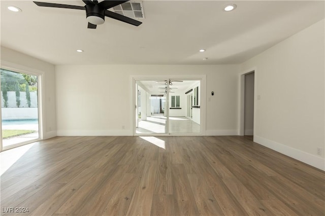 empty room with hardwood / wood-style floors and ceiling fan