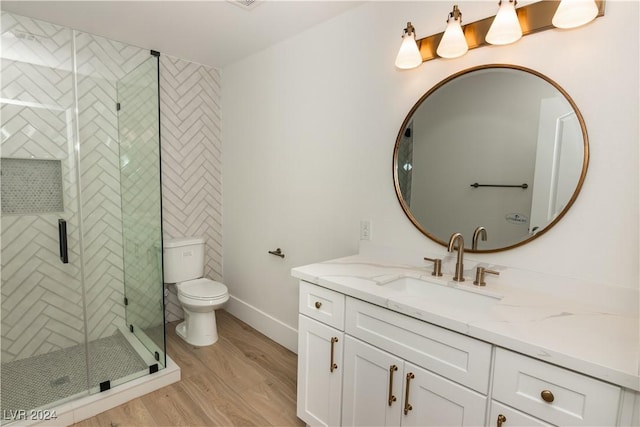 bathroom featuring toilet, vanity, an enclosed shower, and hardwood / wood-style flooring