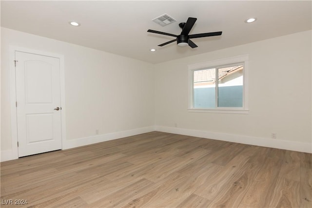 empty room with ceiling fan and light hardwood / wood-style floors