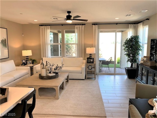 living room with ceiling fan and a wealth of natural light