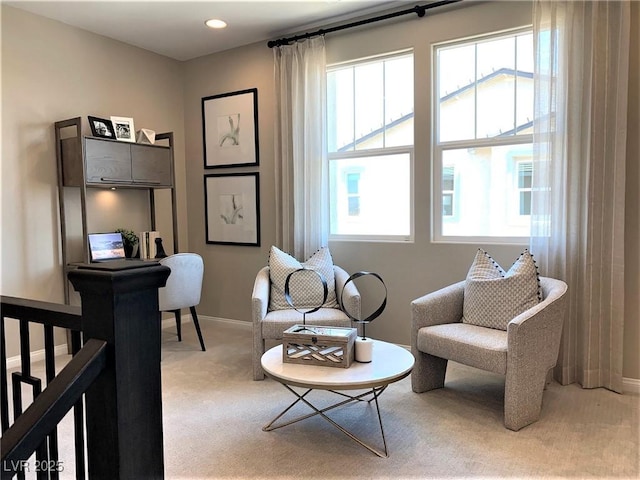 living area featuring a healthy amount of sunlight and light colored carpet