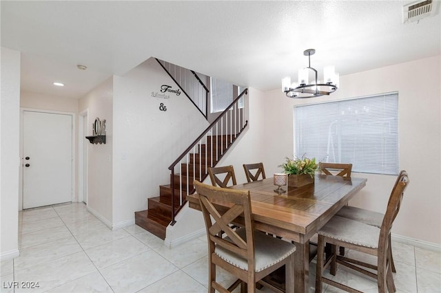 dining area featuring light tile patterned floors and an inviting chandelier