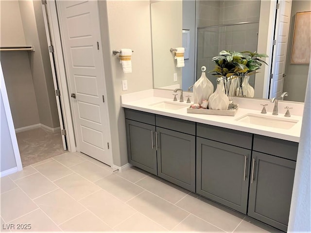 bathroom with tile patterned floors, a shower with door, and vanity