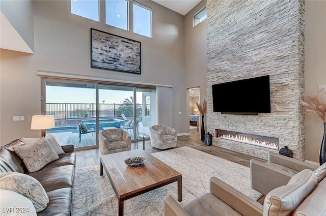 living room featuring a wealth of natural light, a fireplace, and a towering ceiling