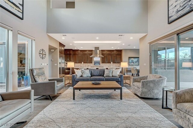 living room with hardwood / wood-style flooring and a towering ceiling