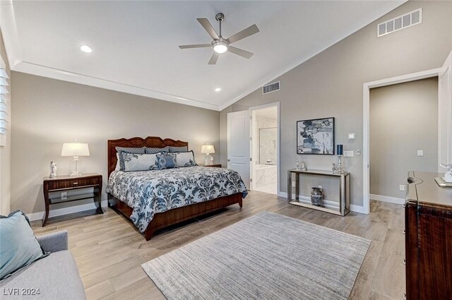 bedroom featuring connected bathroom, light hardwood / wood-style floors, ceiling fan, and lofted ceiling