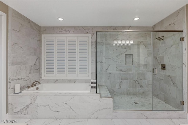 bathroom featuring a marble finish shower and a bath