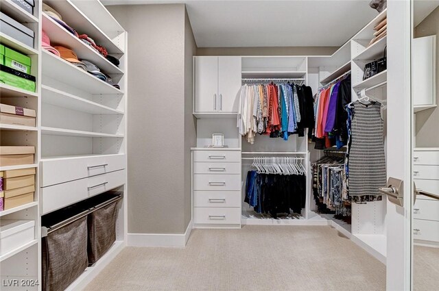 walk in closet featuring light carpet