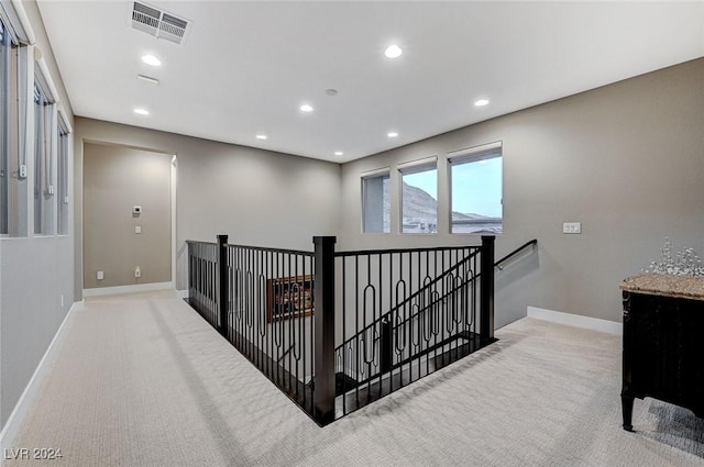 hall featuring light carpet, baseboards, visible vents, an upstairs landing, and recessed lighting