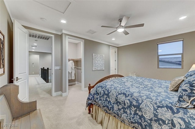 carpeted bedroom featuring ceiling fan, a closet, a spacious closet, and ornamental molding