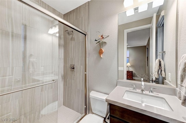 bathroom featuring vanity, toilet, and a shower with door