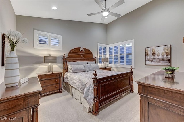 bedroom with ceiling fan, light carpet, and lofted ceiling