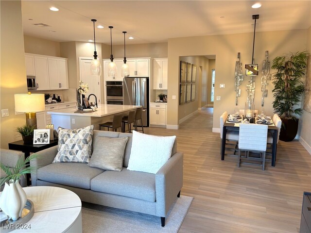 living room featuring sink and light wood-type flooring