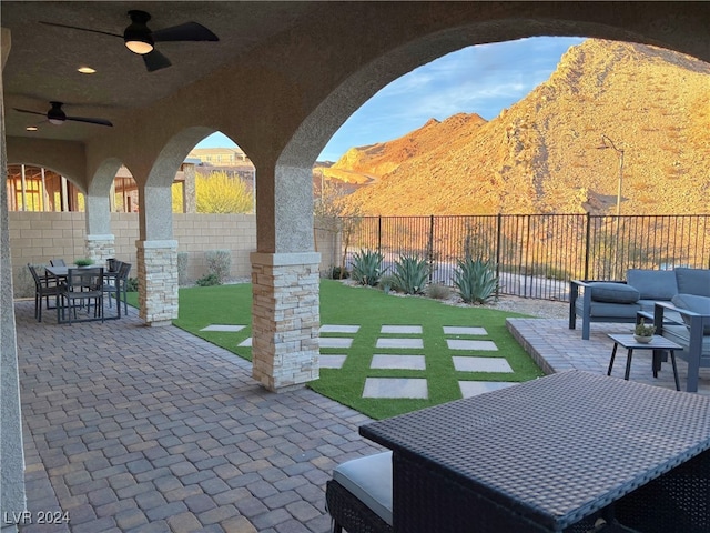 view of patio with a mountain view, outdoor lounge area, and ceiling fan