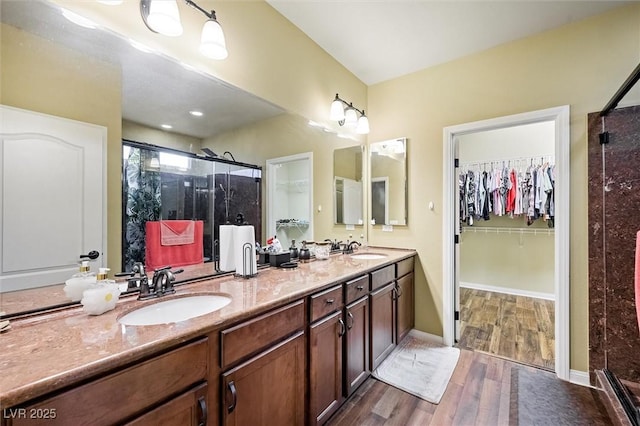 bathroom featuring vanity, wood-type flooring, and a shower with door