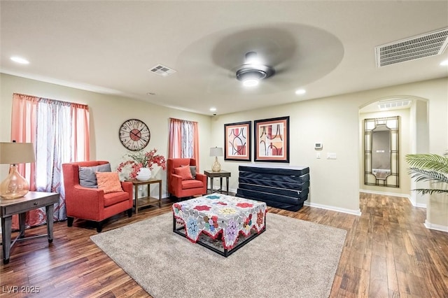 living room with ceiling fan and dark hardwood / wood-style flooring