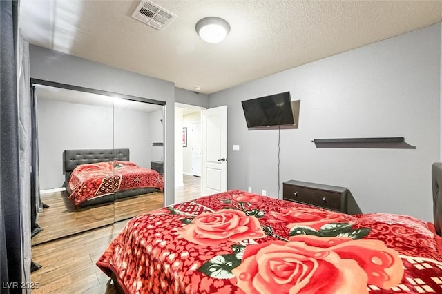 bedroom featuring a closet, hardwood / wood-style floors, and a textured ceiling