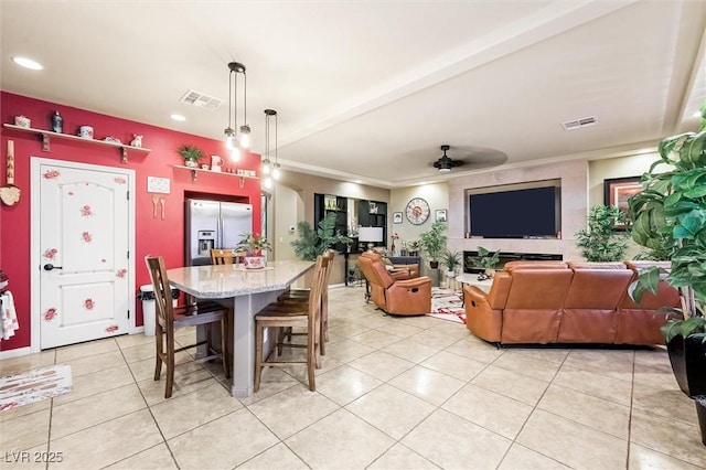 tiled dining area with beam ceiling, ceiling fan, and crown molding